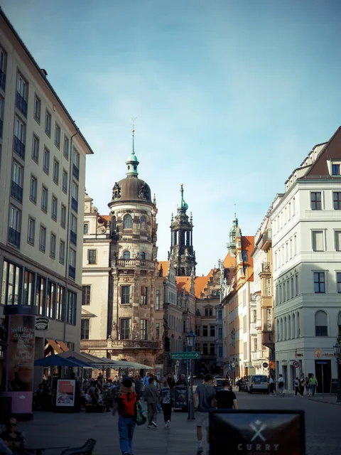 Historische Fassaden und Türme entlang einer Straße in Dresden.