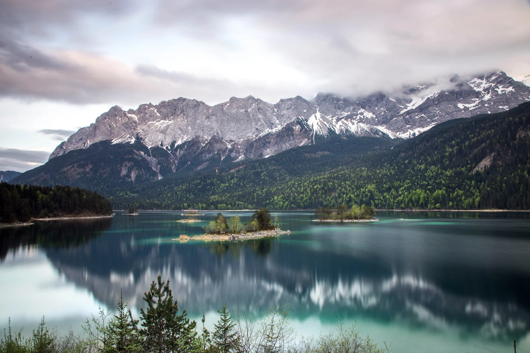 Die smaragdgrüne Wasseroberfläche des Eibsees unter den Bayerischen Alpen.